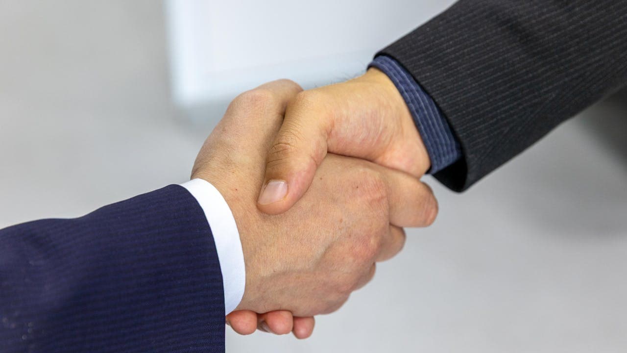 Zwei Menschen geben sich nach einem Beratungsgespräch die Hand