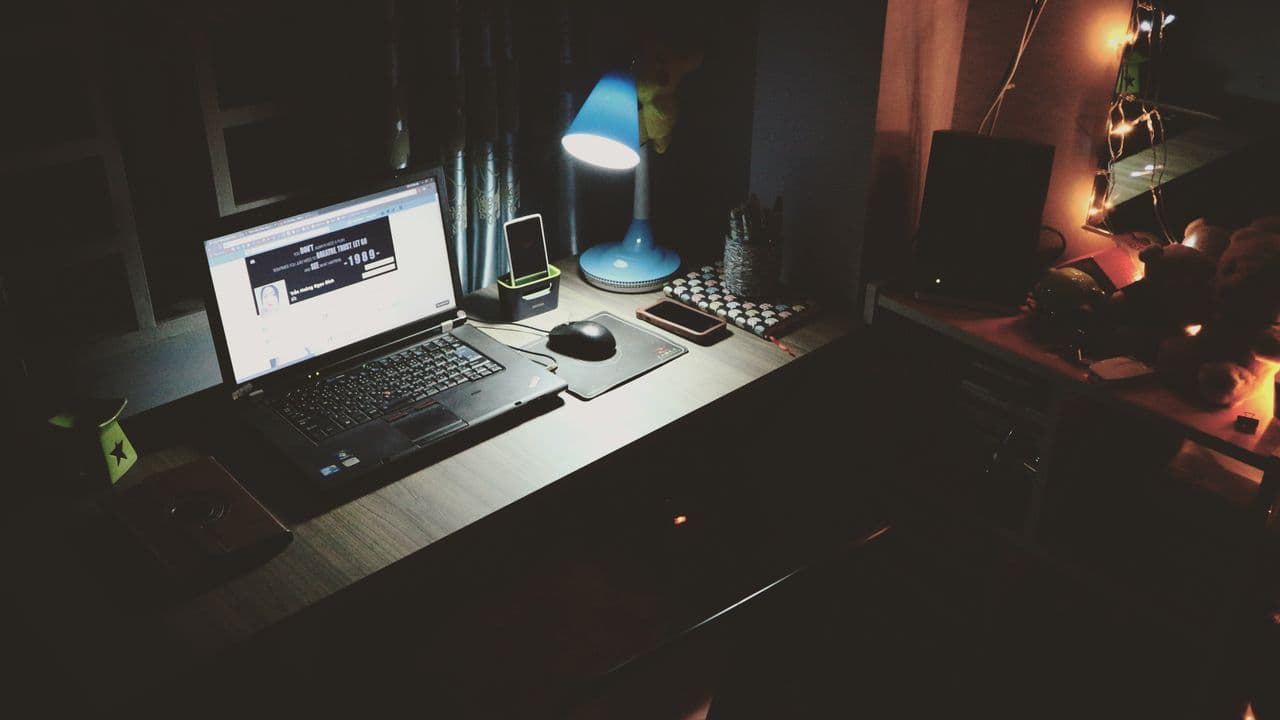 Schreibtisch mit Laptop am Abend