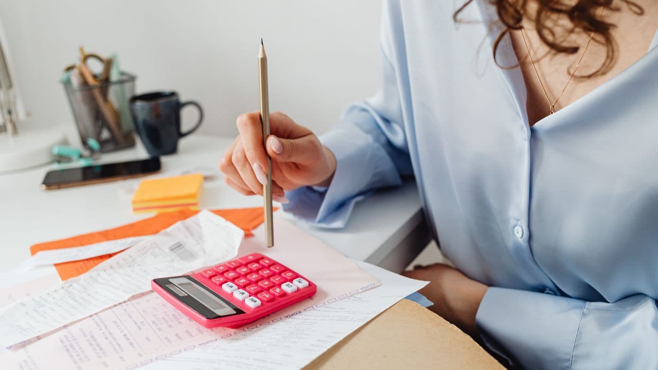 Person prüft eine Rechnung mit Stift in der Hand