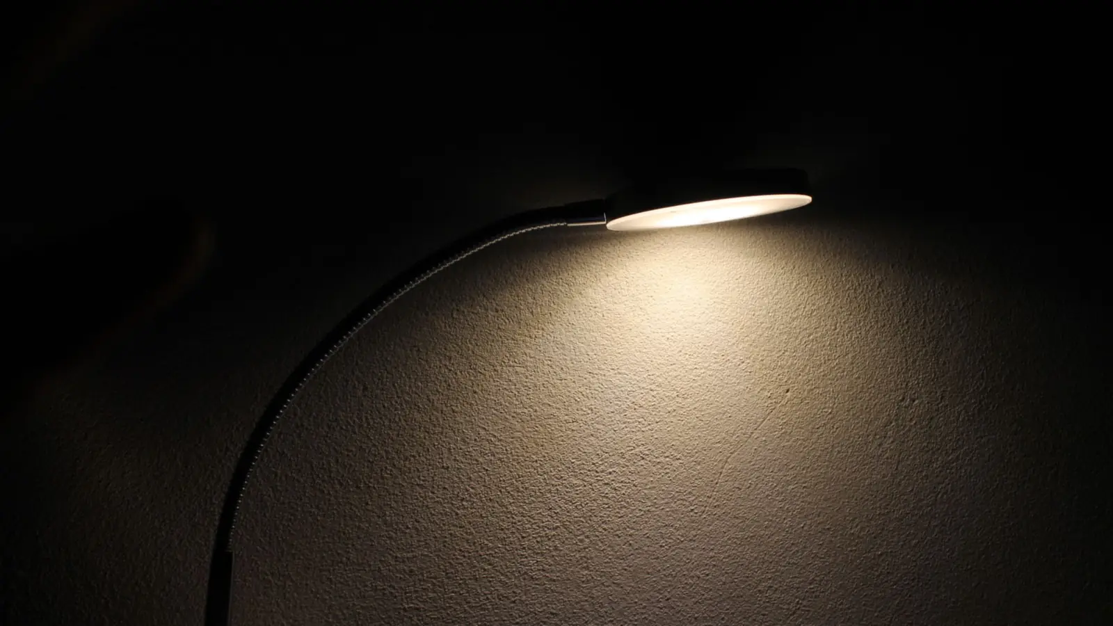 Schreibtischlampe, die eine dunkle Wand beleuchtet